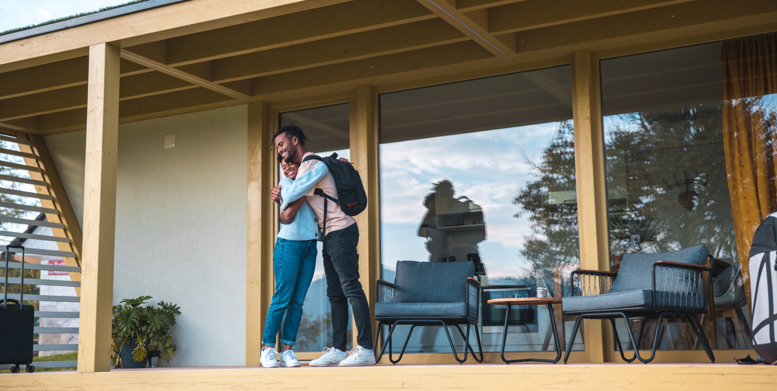 Happy couple hugging in front of new home